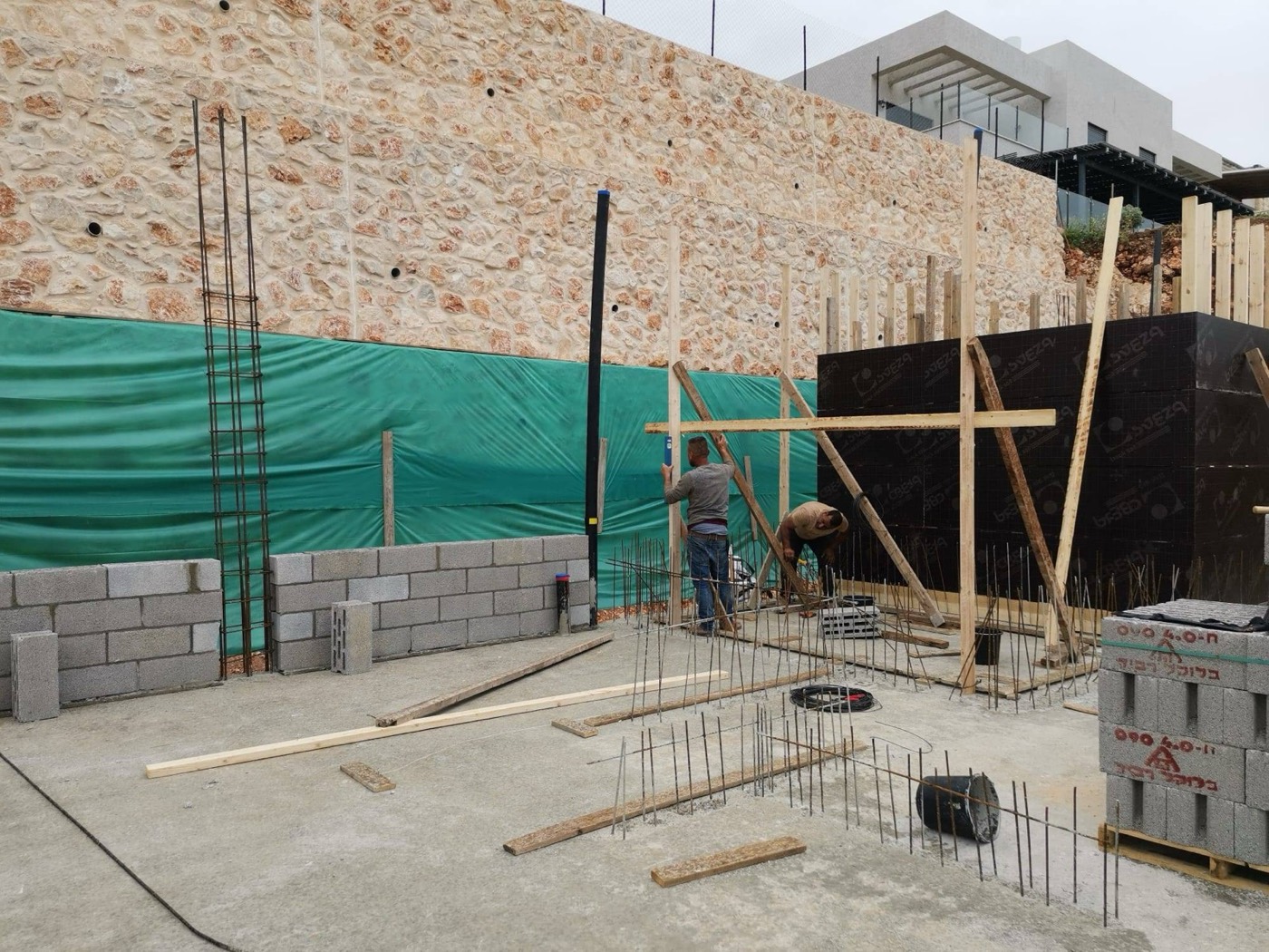 עמודים ותבניות: קשירה, פילוס ואנכיות לפני יציקת השלד.
